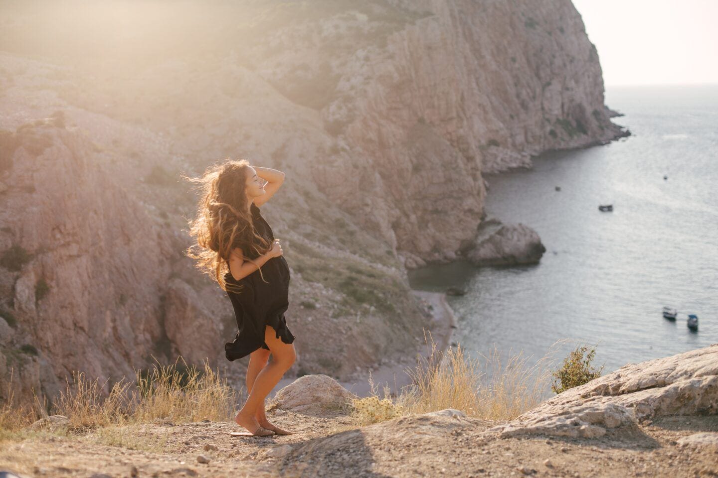7 brilliant tips for traveling during pregnancy traveling during pregnancy, pregnant woman stands on lookout point with water and mountains in background
