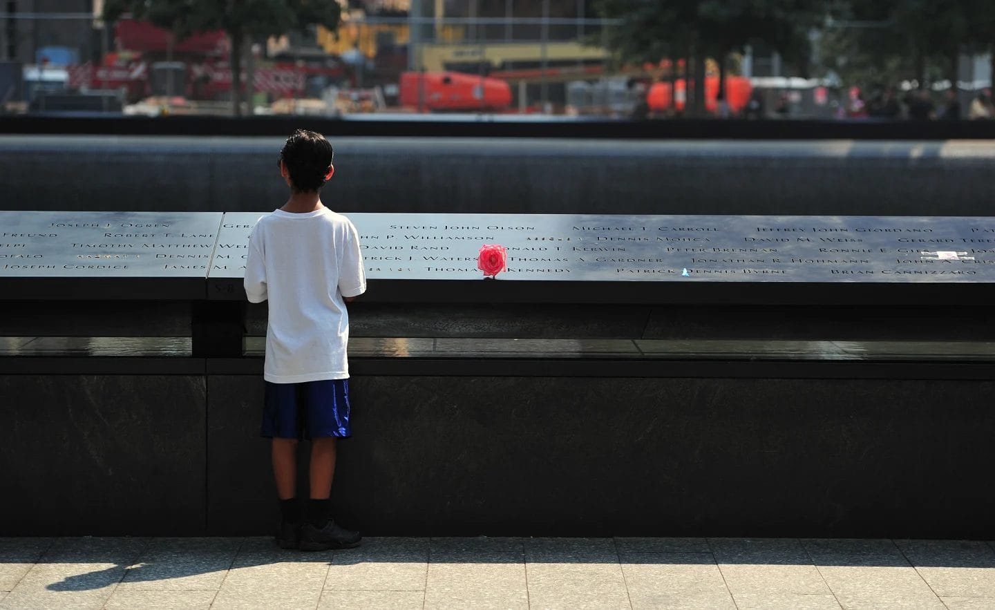 How to talk about 9/11—and other scary world events—with your kids child standing in front of monument- how to talk to kids about 9/11