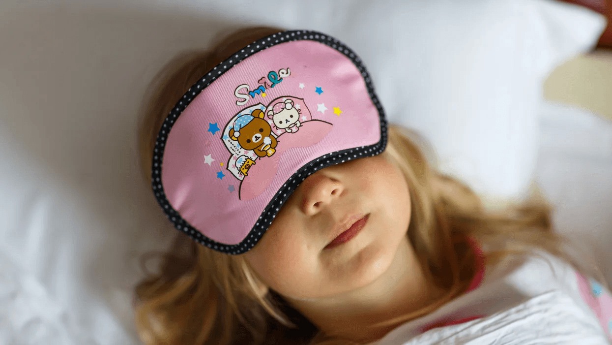 Getting strict on early bedtimes for your kids has scientific benefits—including your own mental health, mama little girl sleeping with an eye mask