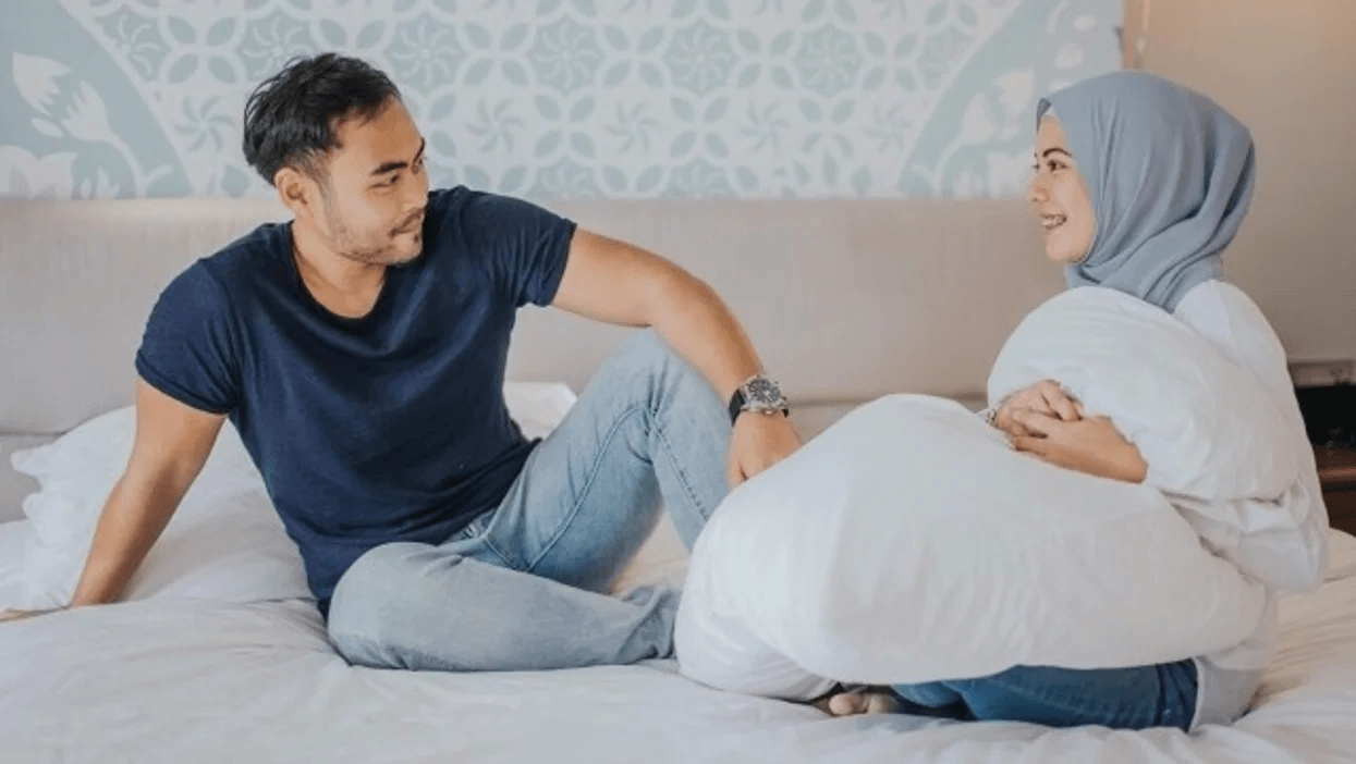 7 tips for communicating with your partner—without being defensive couple sitting on a bed, talking