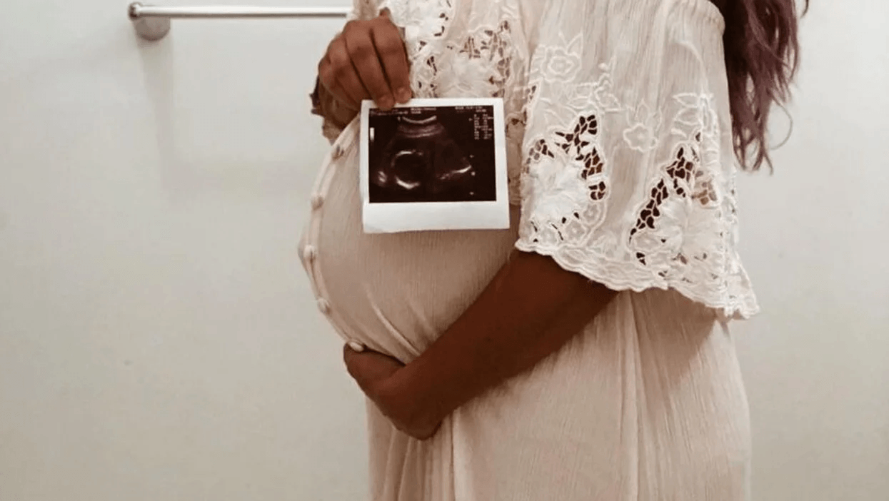 This new finding about why babies move so much in the womb is fascinating pregnant woman holding belly and an ultrasound