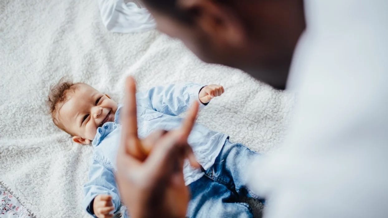 This dad’s bottle-feeding hack is genius—and hilarious dad giving baby i love you sign