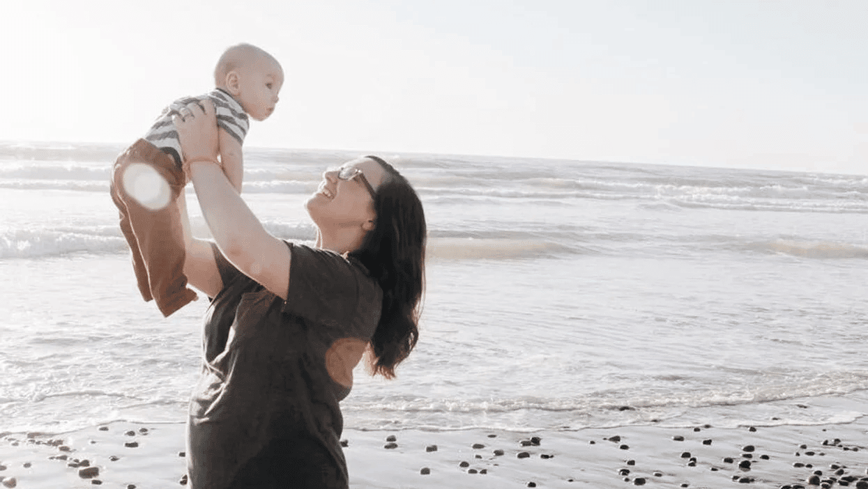 mom playing with baby on a beach