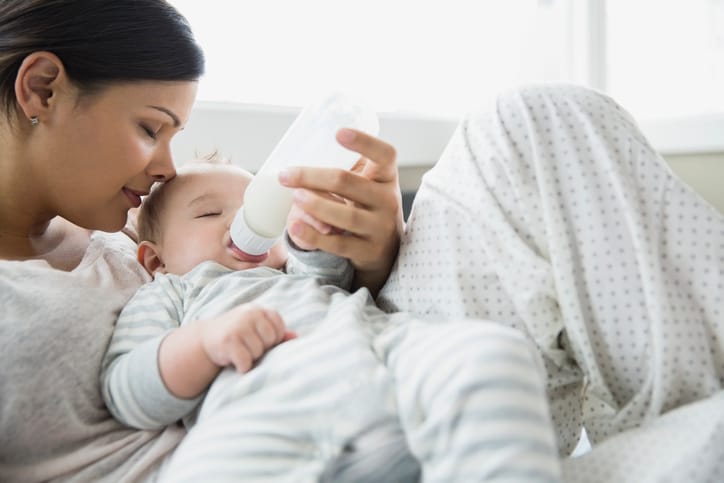 Dream feeds—what are they and are they right for your baby? a woman feeding a baby