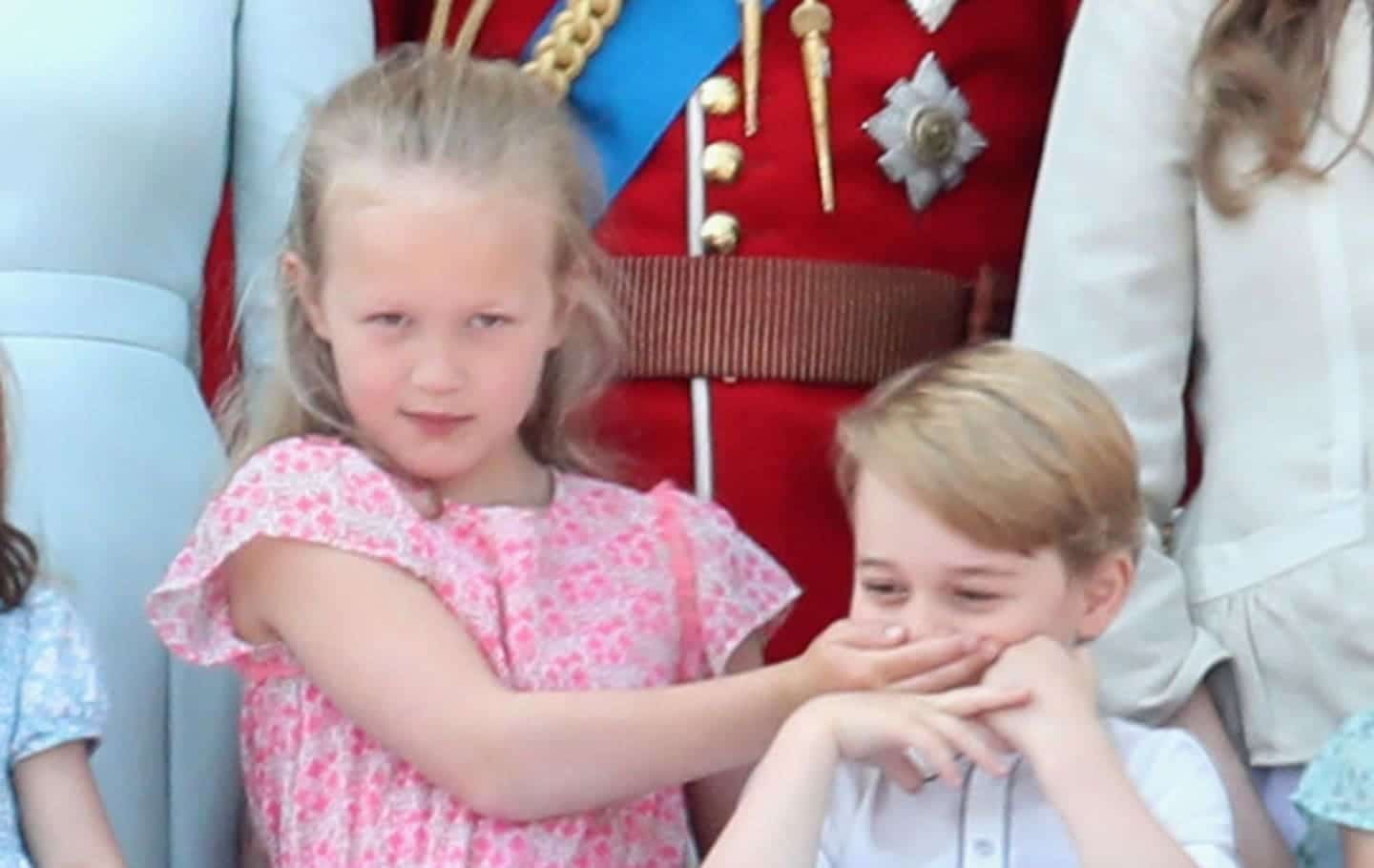 5 photos of the royal kids being kids during the Queen’s birthday parade Savannah Phillips covering Prince George's mouth.