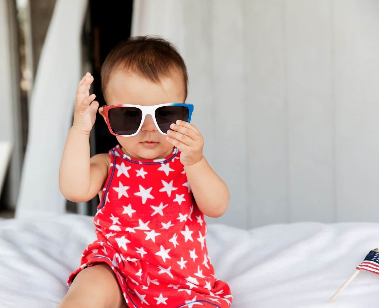 17 must-know tips to survive your first 4th of July with a baby baby wearing fourth of july themed sunglasses- baby's first 4th of july