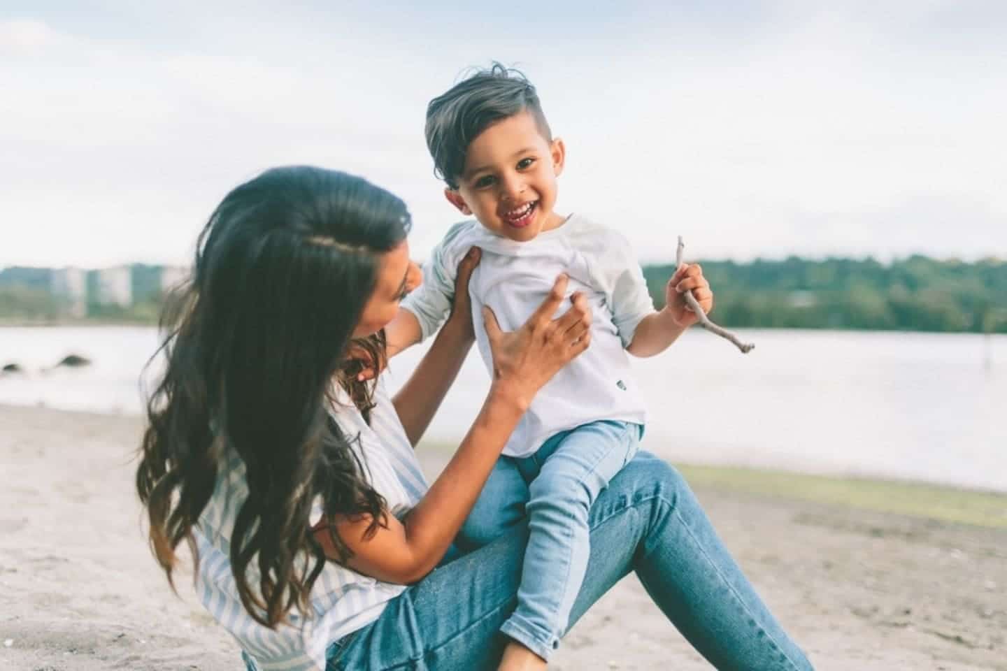 Half of today’s young adults want fewer kids than their parents woman carrying and playing with toddler
