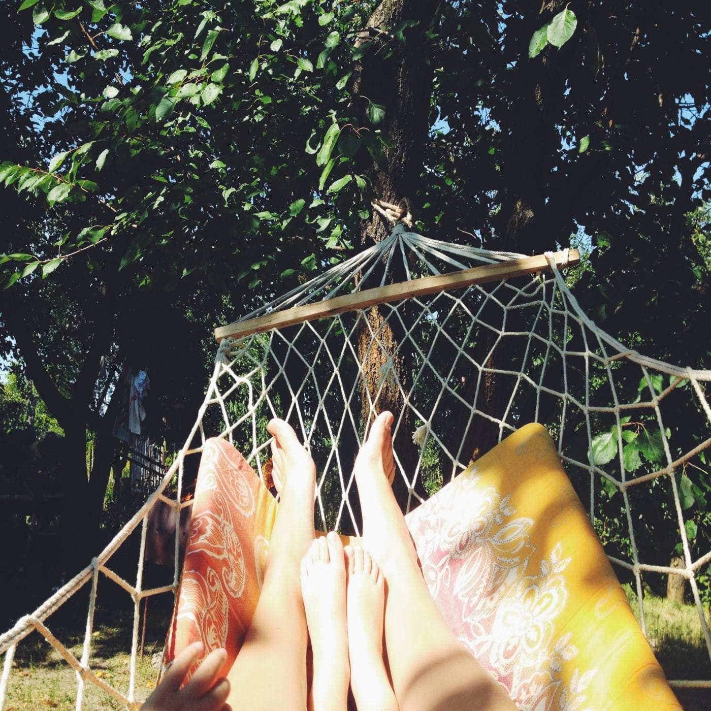 Why we are doing nothing this summer adult and child legs shown on hammock in summer