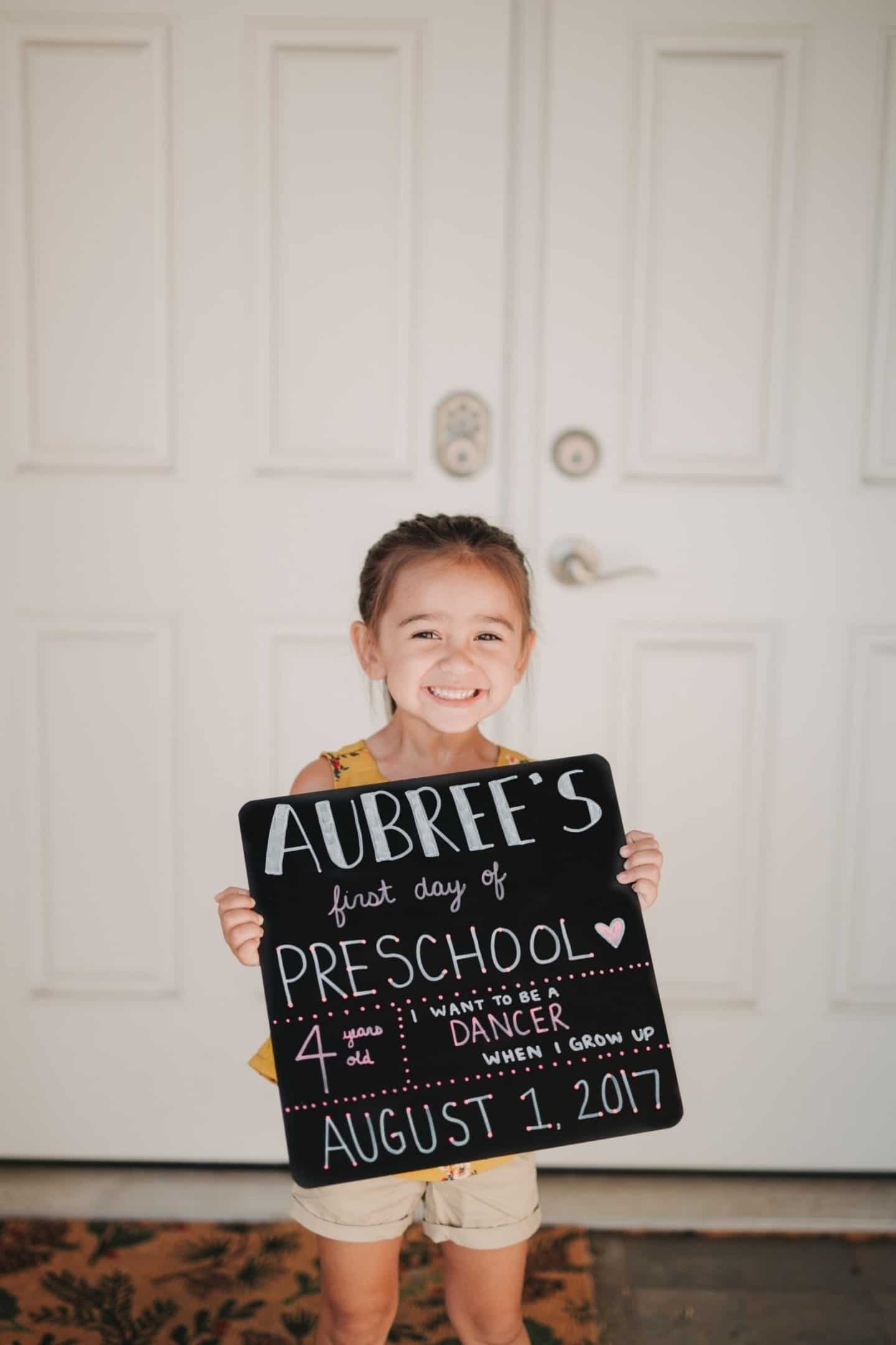 9 ways to make the back to school transition easier on your kids—and yourself child holding a poster