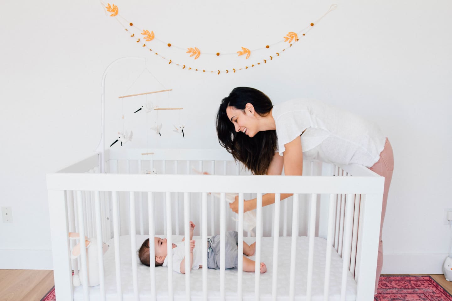 Motherly Studios custom video solutions mom playing with baby, who is in the crib