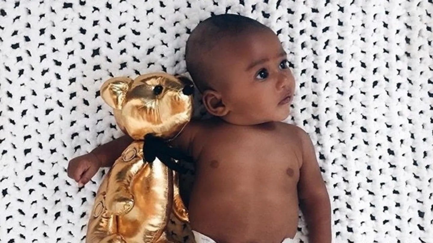 The 4-month sleep regression struggle is real baby laying down with a gold stuffed bear - 4 month sleep regression stories