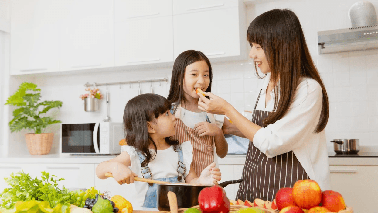 15 proven ways to get your kids to eat healthier meals 🥙 woman cooking with two daughters