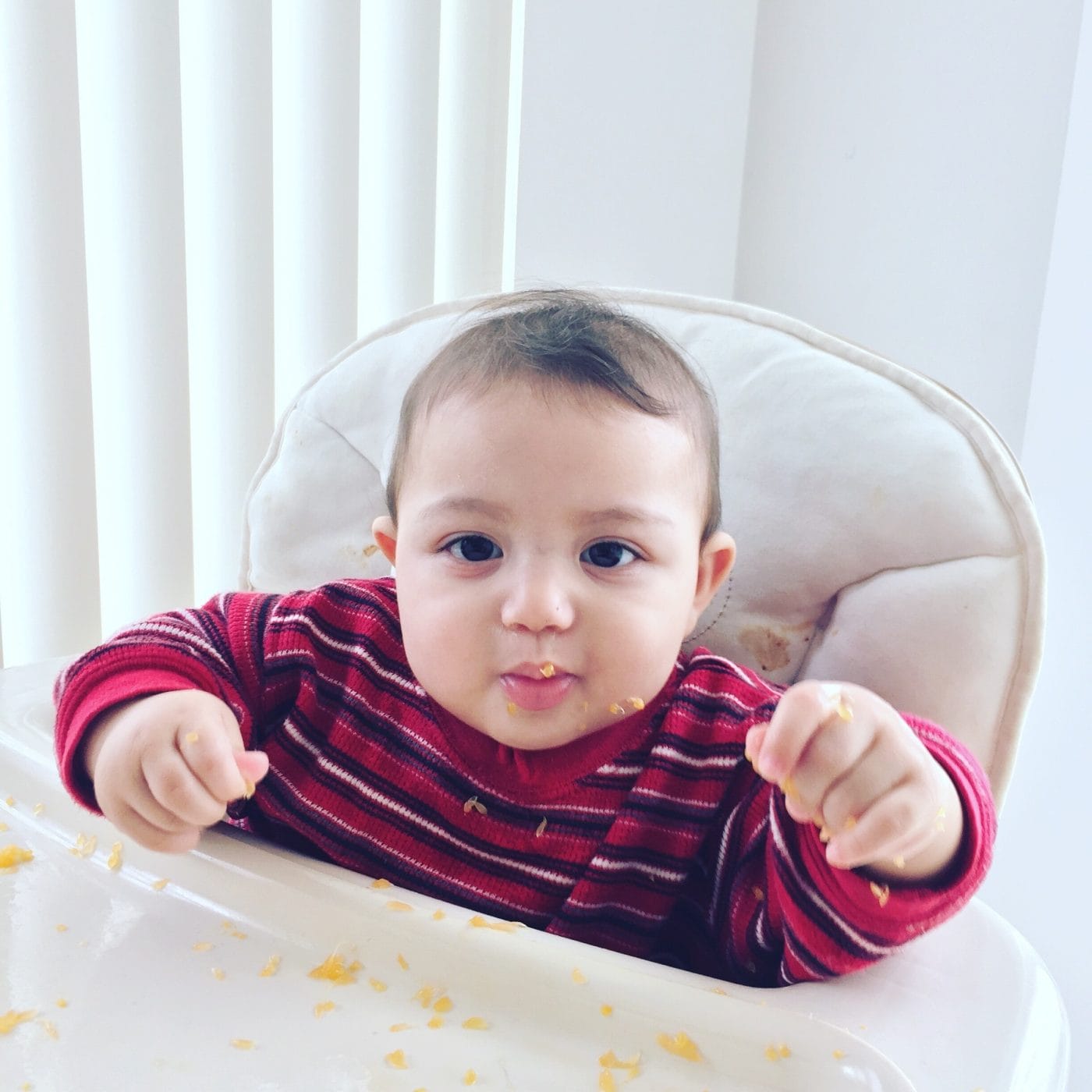 10 nutrient-dense first foods for baby a baby sitting in a high chair eating