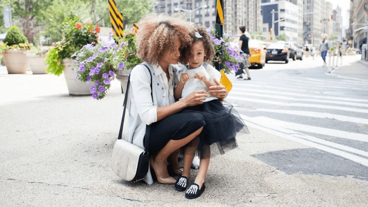 8 working moms share how they find work-life balance mom holding little girl on the sidewalk
