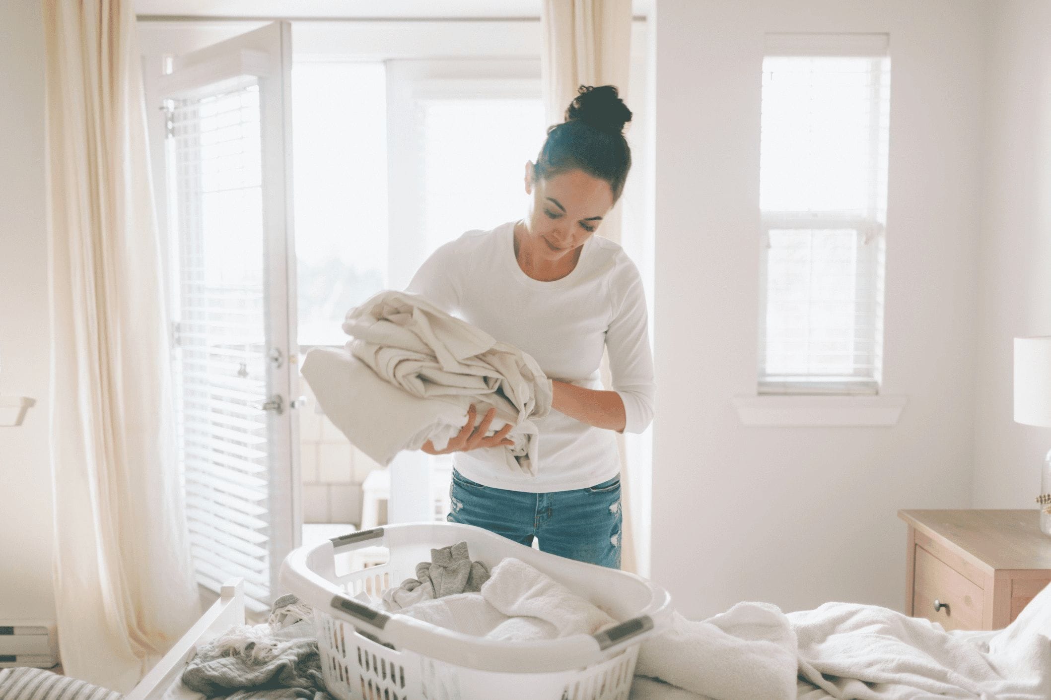 Getting rid of “stuff” saved my motherhood woman folding laundry