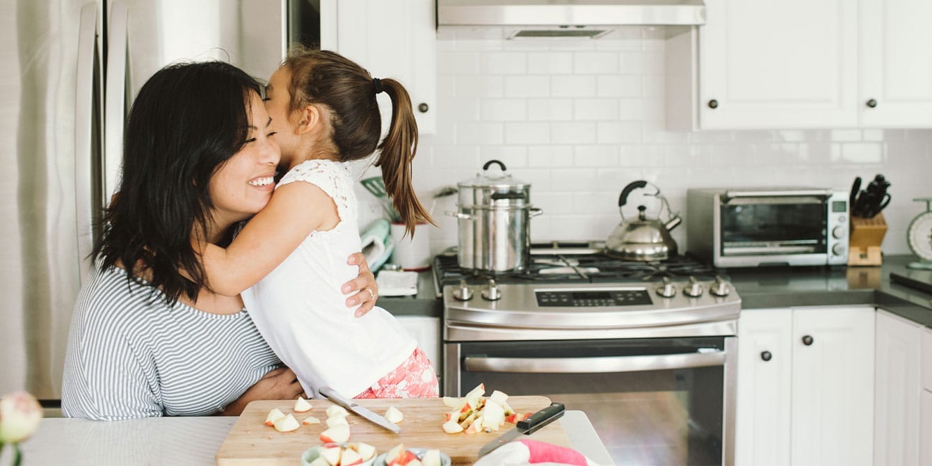 11 simple ways to raise grateful kids mother and daughter hugging in the kitchen- how to raise grateful children