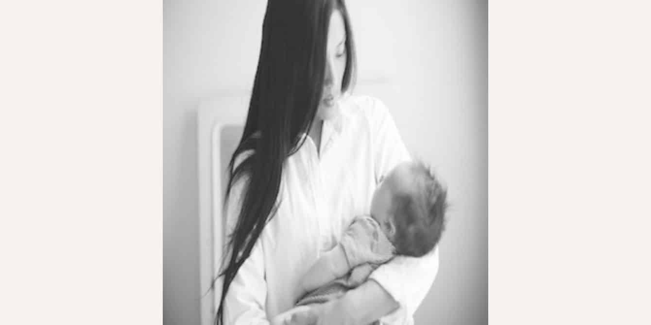 Leah K on her traumatic birth and the darkness of postpartum depression woman holding baby thinking of traumatic birth