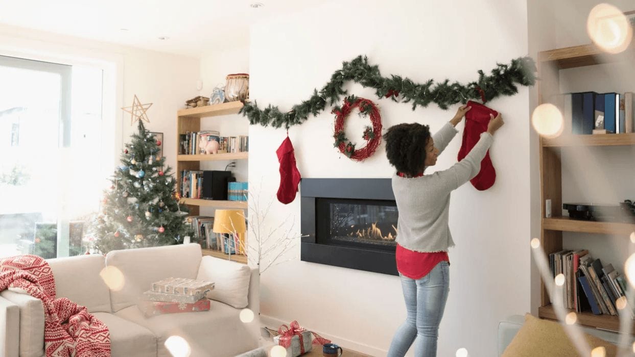 Holiday prep: 50 items to sell, donate or toss now woman hanging up holiday decorations
