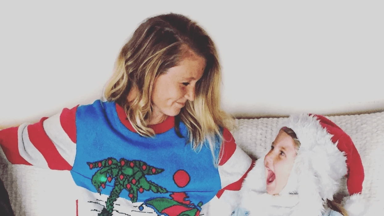 I am Santa Claus, the elves and Christmas magic mom wearing christmas sweater smiling at child wearing santa hat- moms make christmas happen