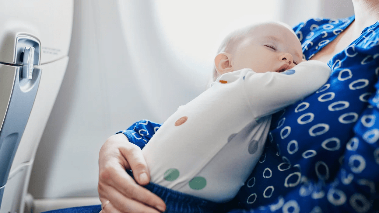 Holiday travel with baby: 6 products to make it stress-free, mama baby-sleeping-on-mom-on-a-plane