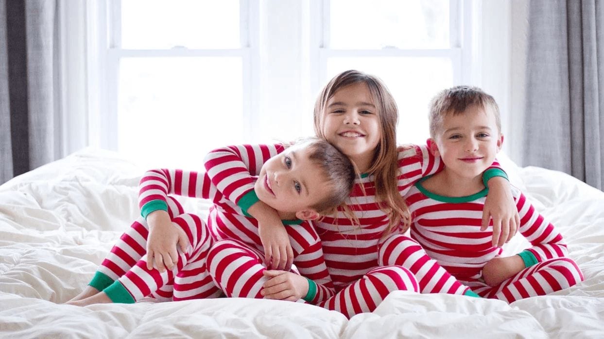 The holiday tradition we look forward to every year siblings wearing matching holiday pajamas