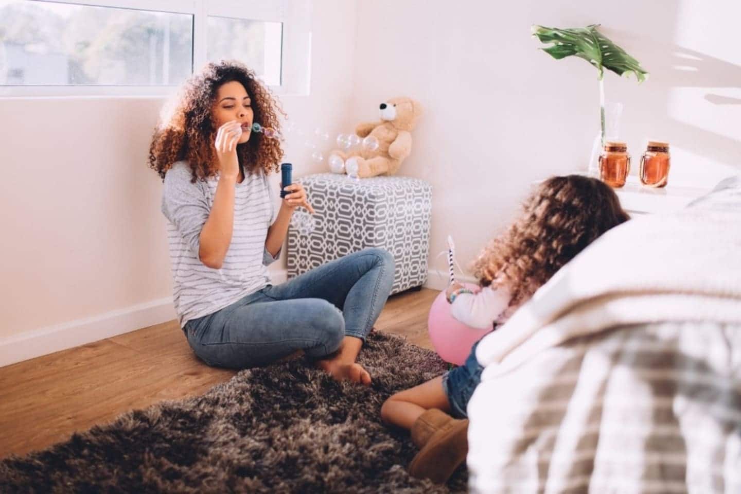 I want to be a stay-at-home mom AND a working mom mom sitting on the floor blowing bubbles with daughter