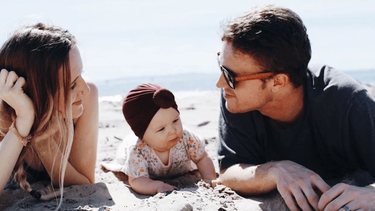 Dear husband: I need more attention and affection from you than ever before couple laying on a beach with their baby