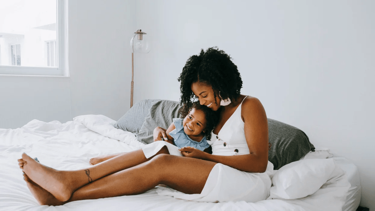 Minimalism drastically improved my mental health–and my motherhood mom reading to daughter in bed