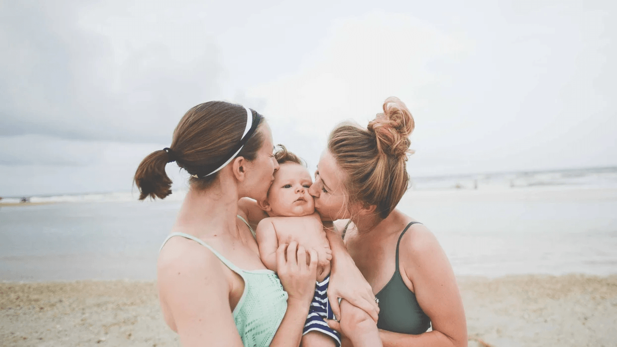 Living close to my sister made such a huge difference when I became a mom two women kissing toddler on the cheek