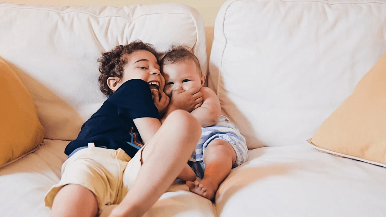 Motherhood is: Wishing I could freeze time toddler and baby siblings hugging on the couch- don't you ever grow up