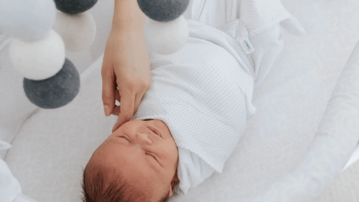The fascinating connection between your baby’s sleep and language development baby wearing a sleep sack in a crib