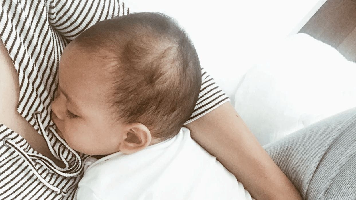 15 mamas share their child’s nap schedule mom holding baby while she naps