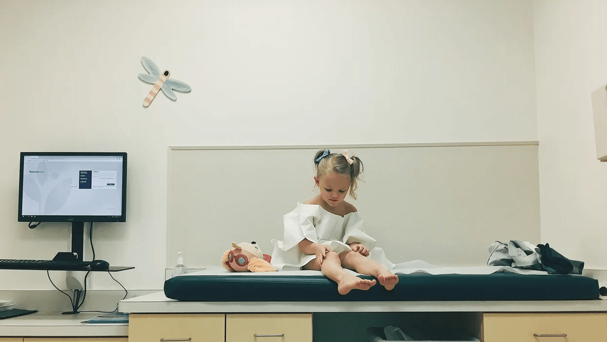 New massive study debunks the MMR vaccine & autism myth that has stressed so many parents little girl sitting on a doctor's table