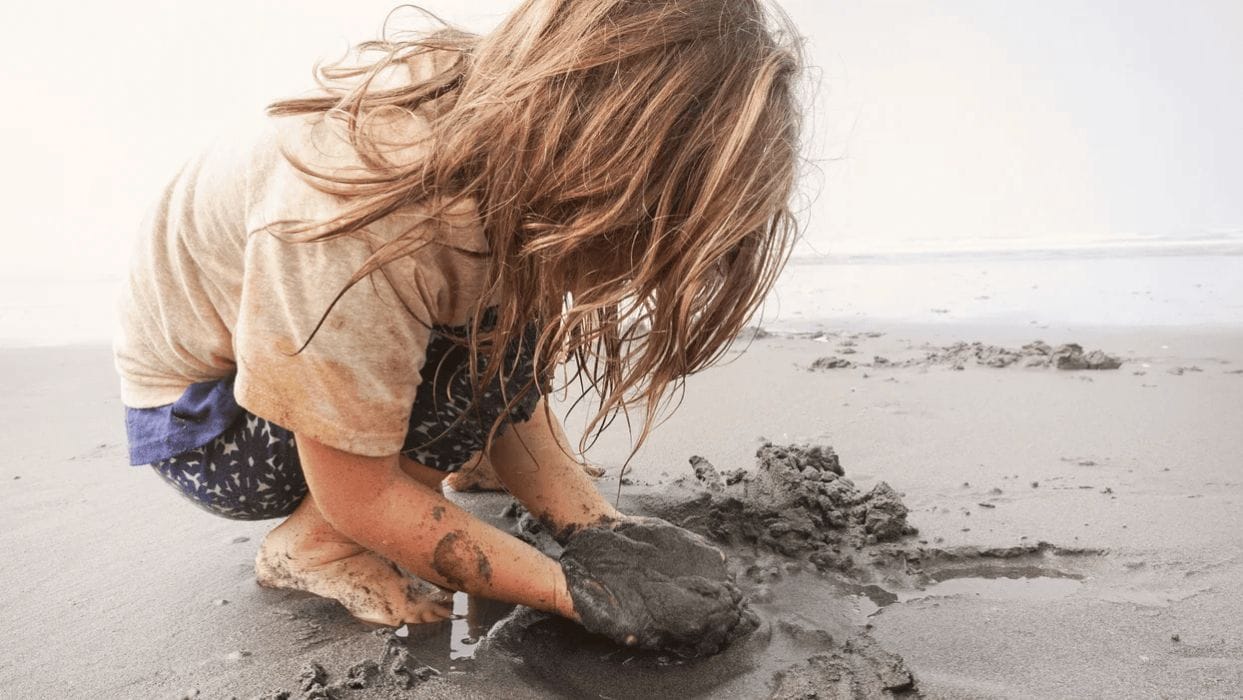 Letting kids get dirty has lifelong health benefits little kid playing with wet sand