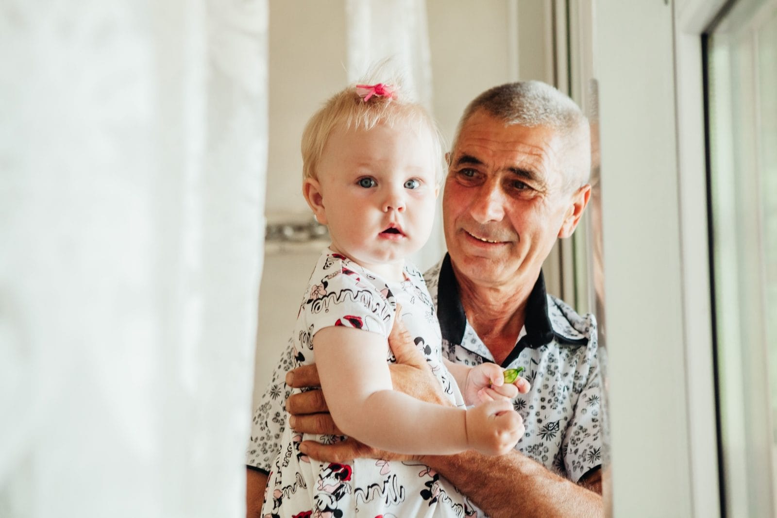 72% of older Americans strongly oppose paying for universal childcare, says new survey a grandfather holding hs granddaughter