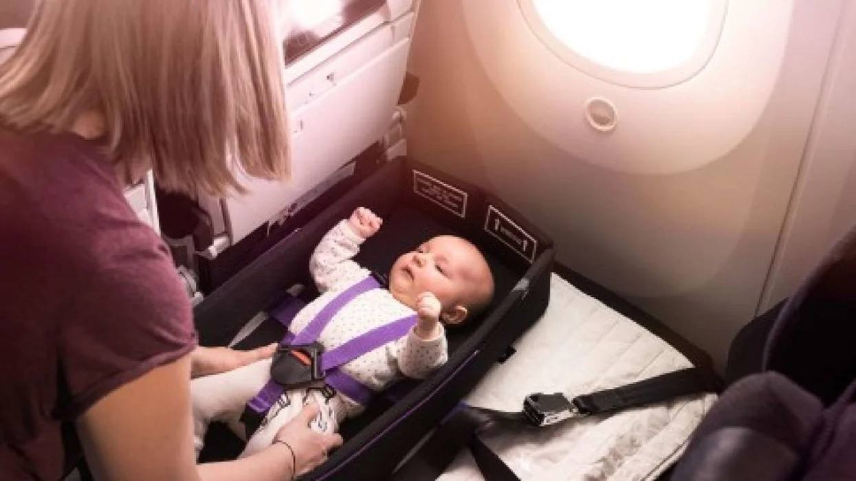 Amazing ‘Skycouch’ lets babies sleep comfortably on planes mom putting baby in a Skycouch