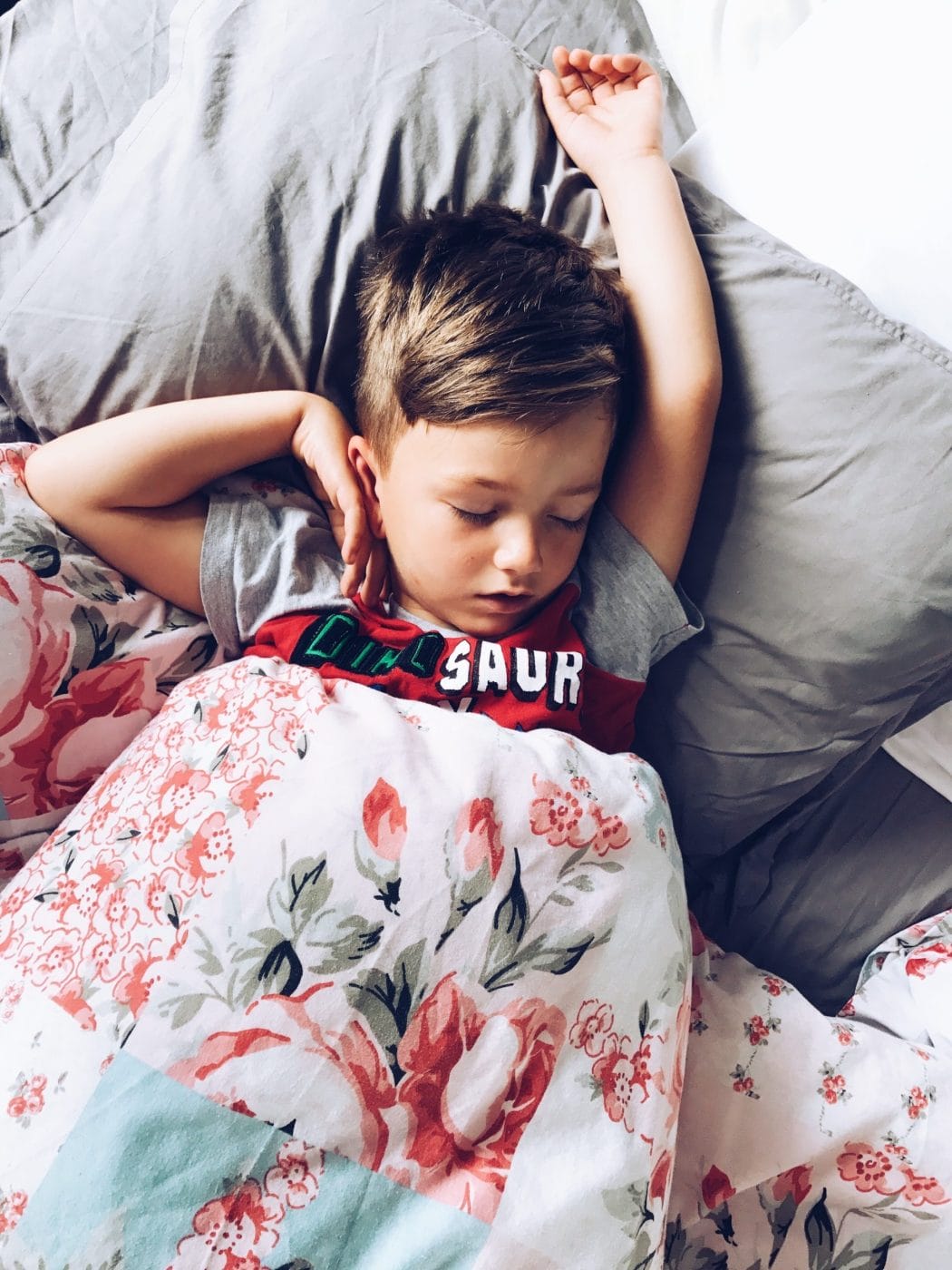 Why your kindergartener may still benefit from a nap a boy sleeping in bed with his arms behind his head