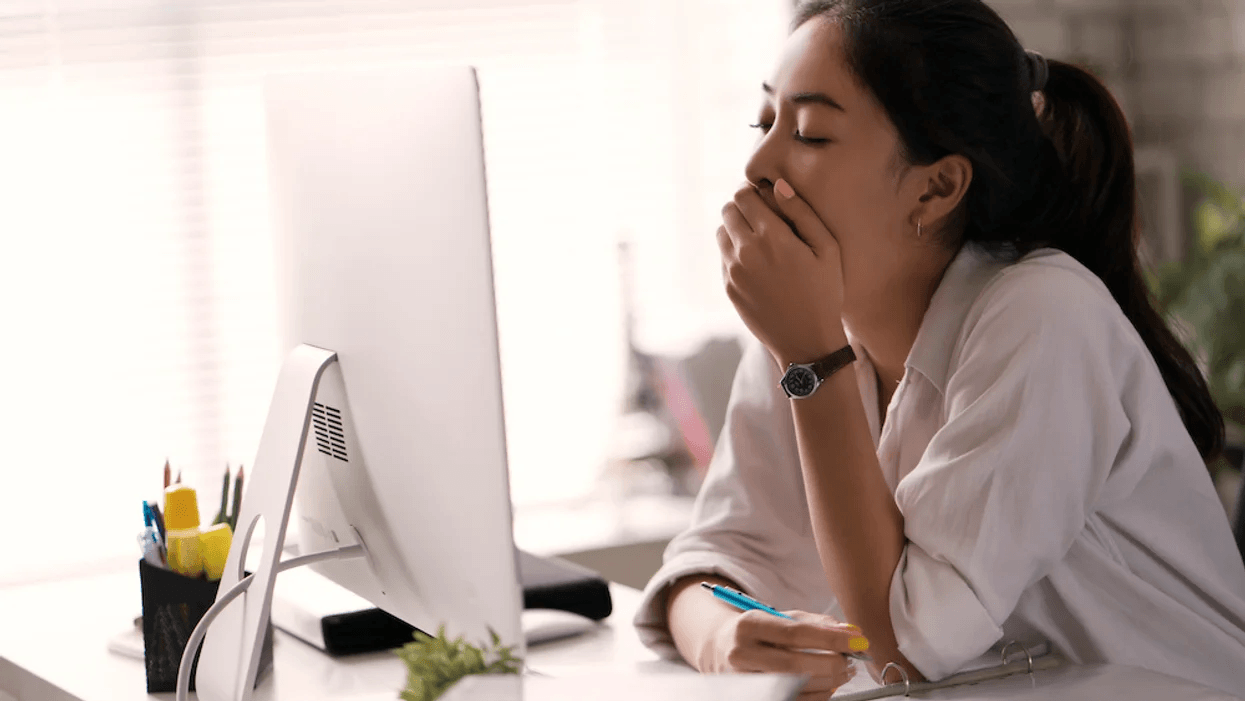 New moms spend 105 days tired at work after maternity leave woman yawning at computer screen