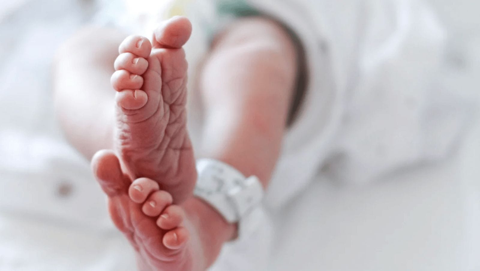 Wow–first American baby born from a uterus transplant from a deceased donor baby feet with a hospital blanket on the ankle