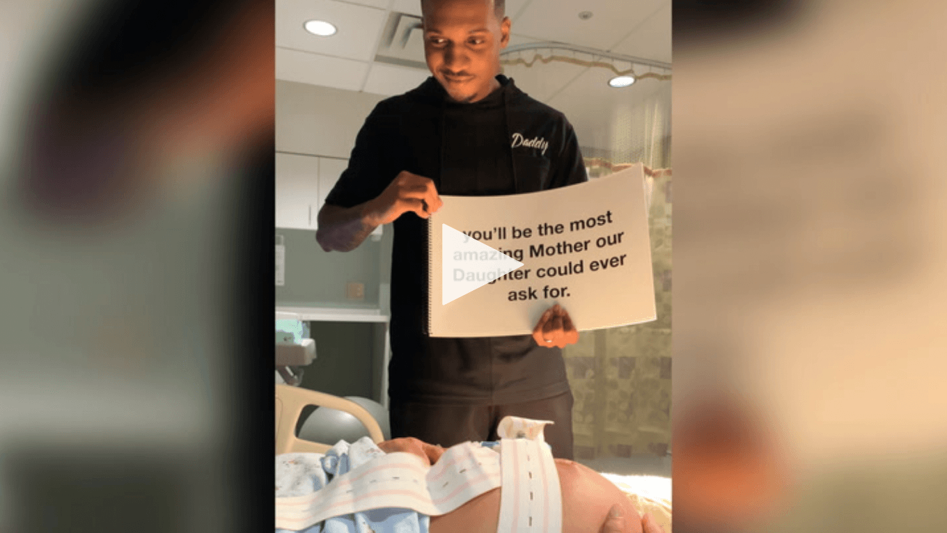 Our favorite viral mama & kid videos video screenshot of dad holding up supportive signs to mom in labor