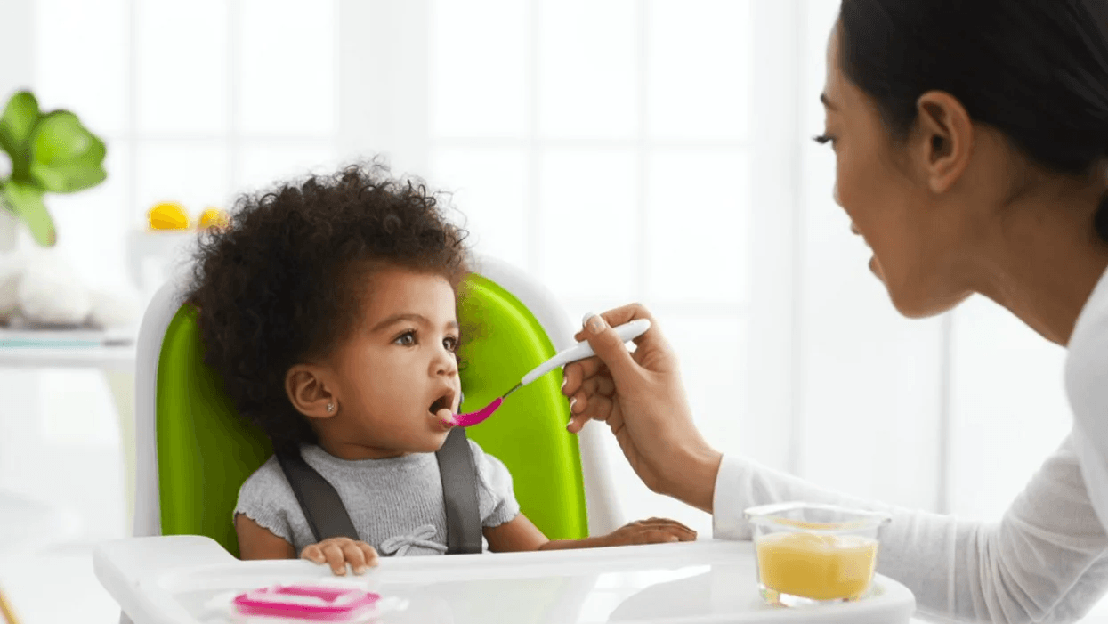 These essentials will make transitioning to solid foods a snap, mama mom feeding baby sitting in a high chair