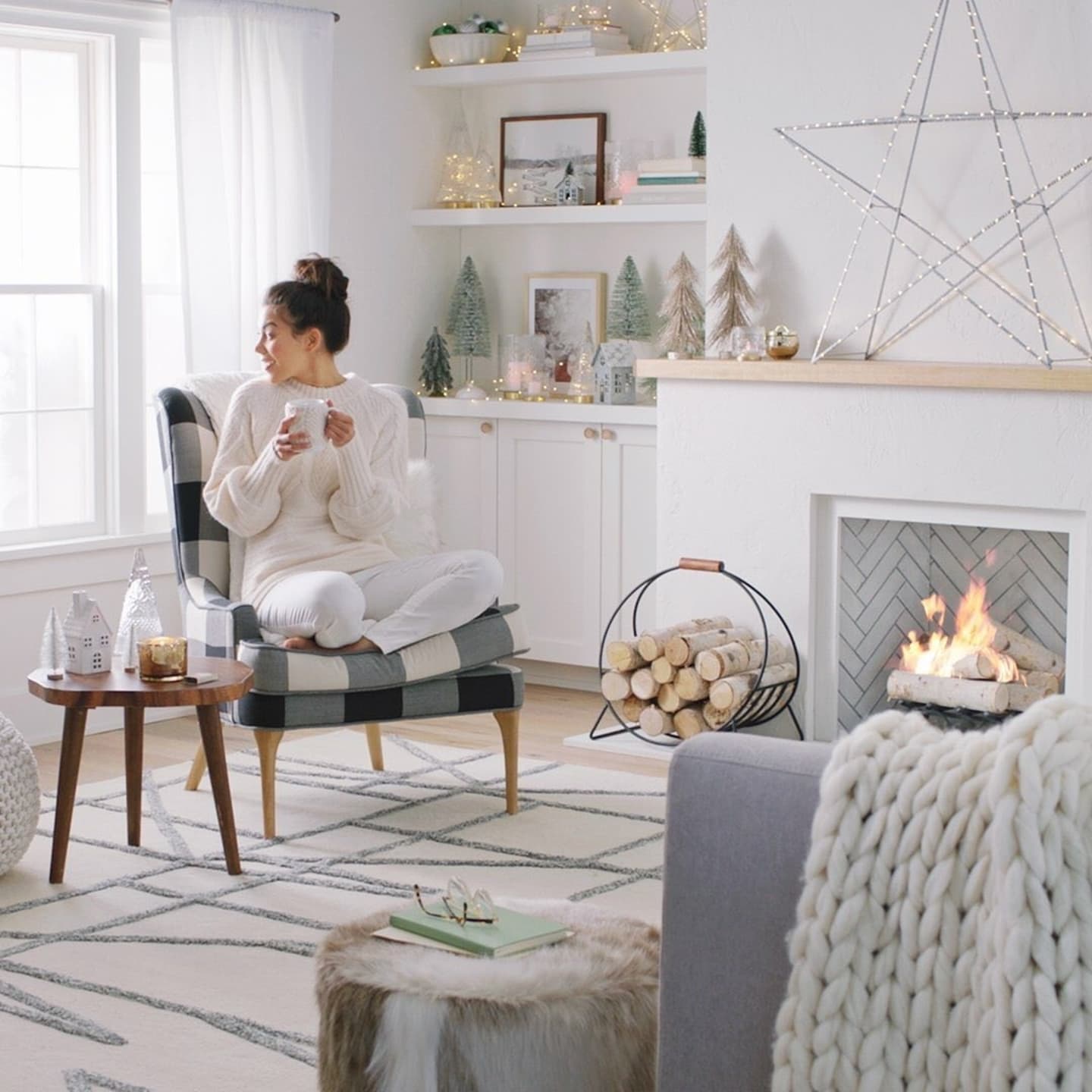 Target has all the minimalist holiday decorations you need (under $50!) woman cozied up next to a fire