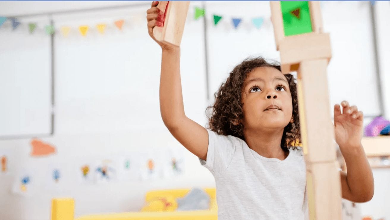 Montessori at home: Choosing holiday gifts that encourage independent play little kid playing with wooden blocks