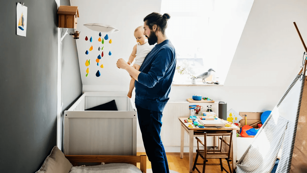 We can’t get enough of these unique gender-neutral nursery color palettes 😍 dad holding a baby in a nursery