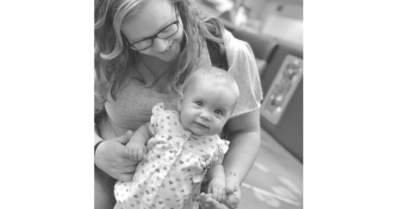 Taylor on how she finally admitted to her husband she needed help women holding and looking at baby while baby looks at camera
