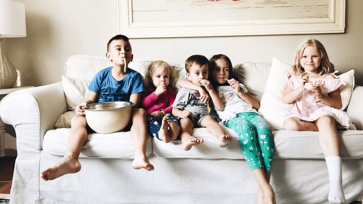 100+ movies you need to watch with your kids at least once🍿 kids on the couch watching a movie and eating snacks