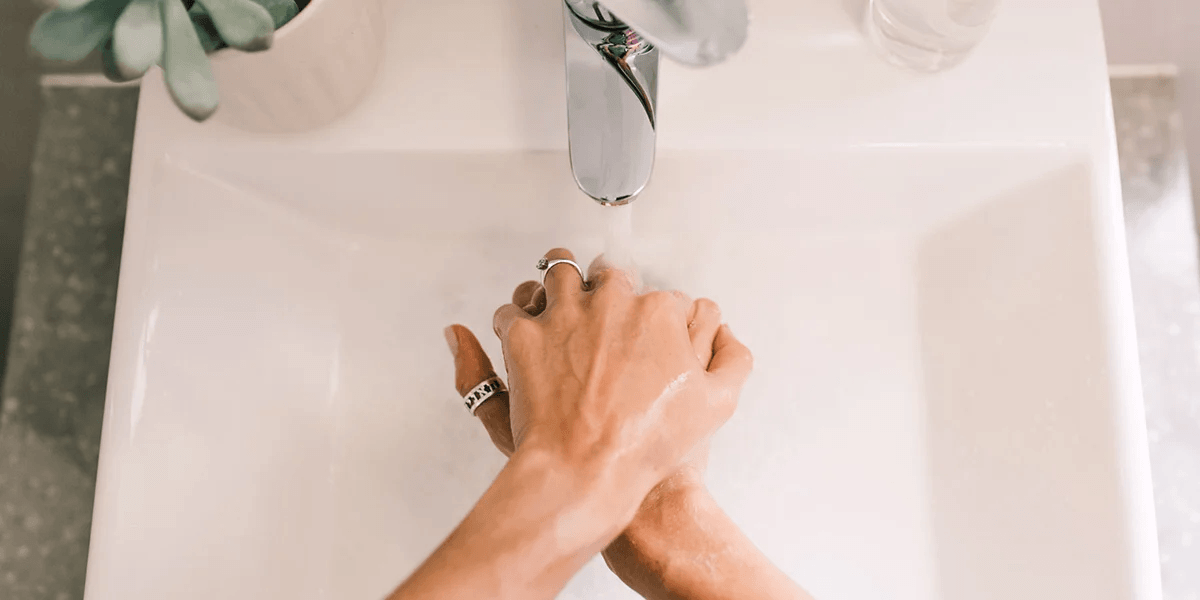6 immune-boosting steps to beat back-to-school germs woman washing hands under sink