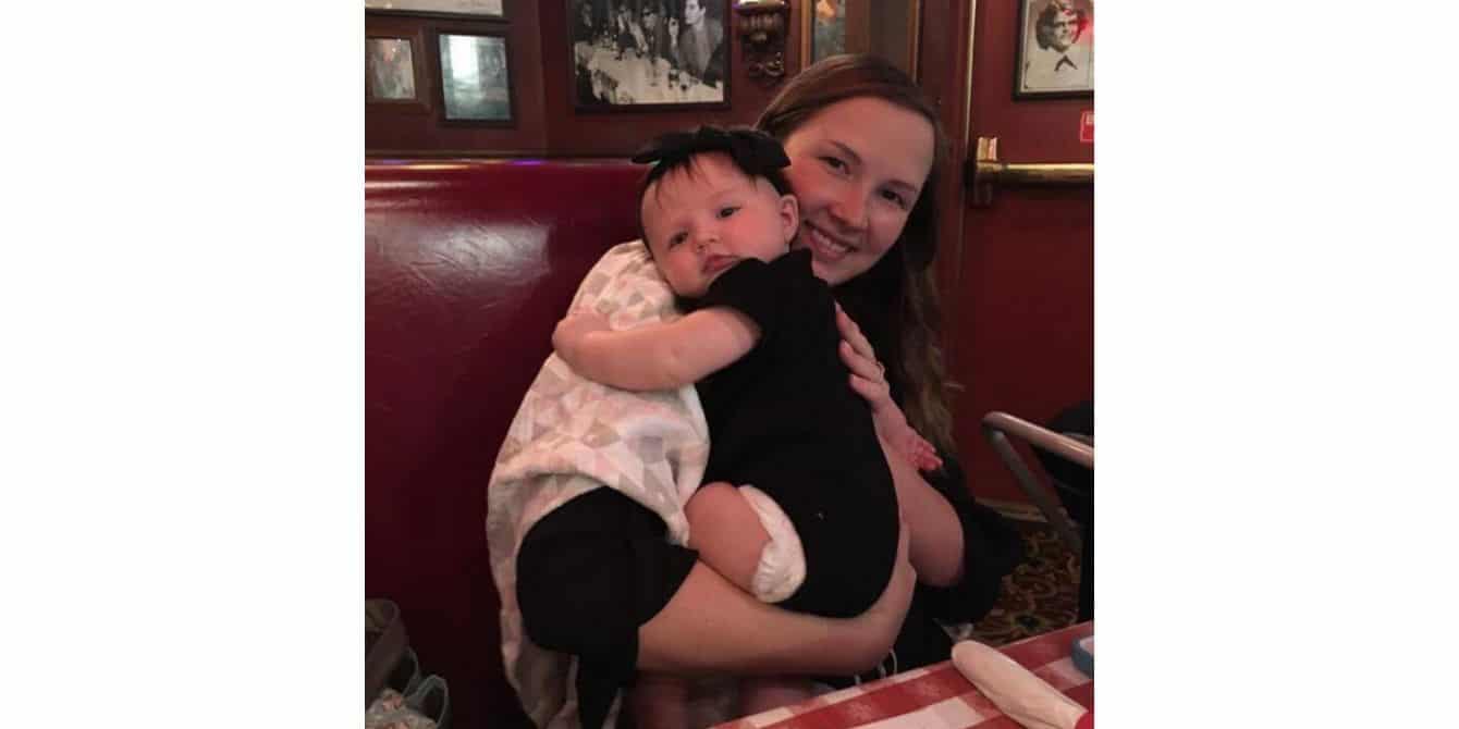 Rachael on how she tried to ignore her postpartum depression women holding her baby and smiling for the camera