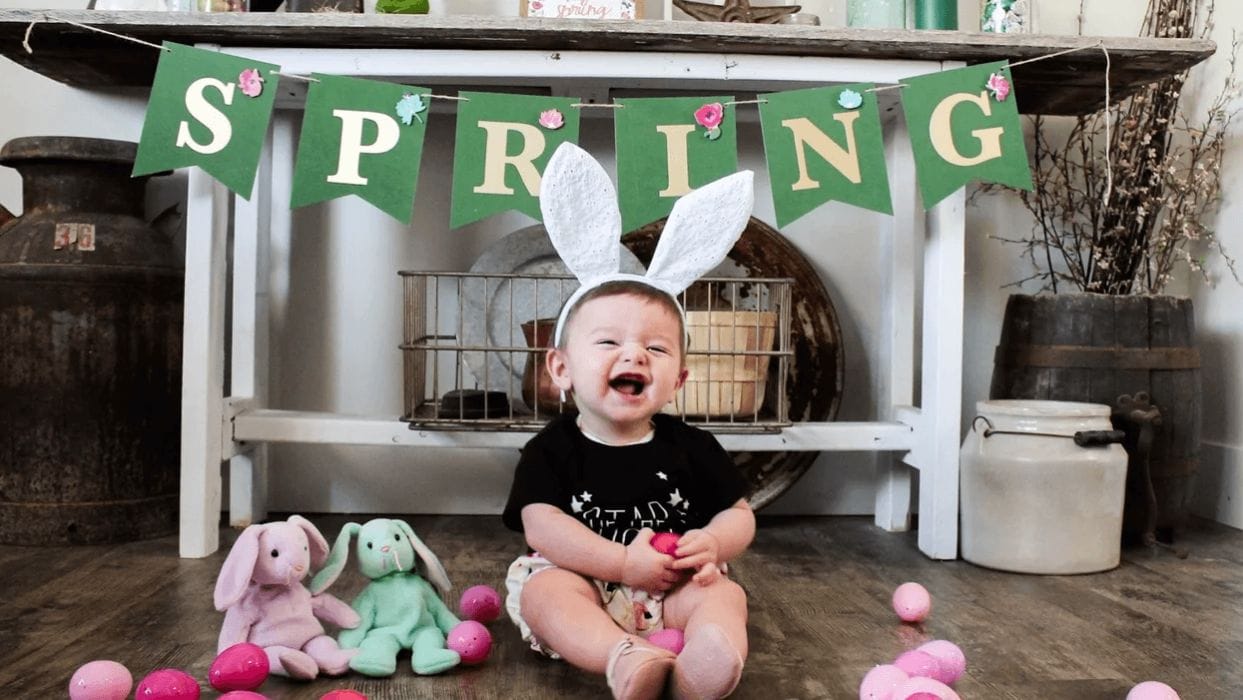 10 fun & easy Easter crafts for kids of all ages đ° baby sitting in front of a spring sign