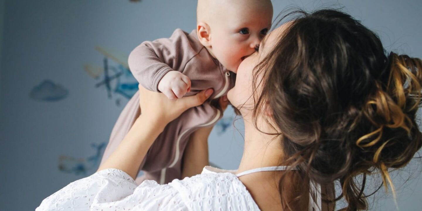 mom kissing baby - popular baby boy names
